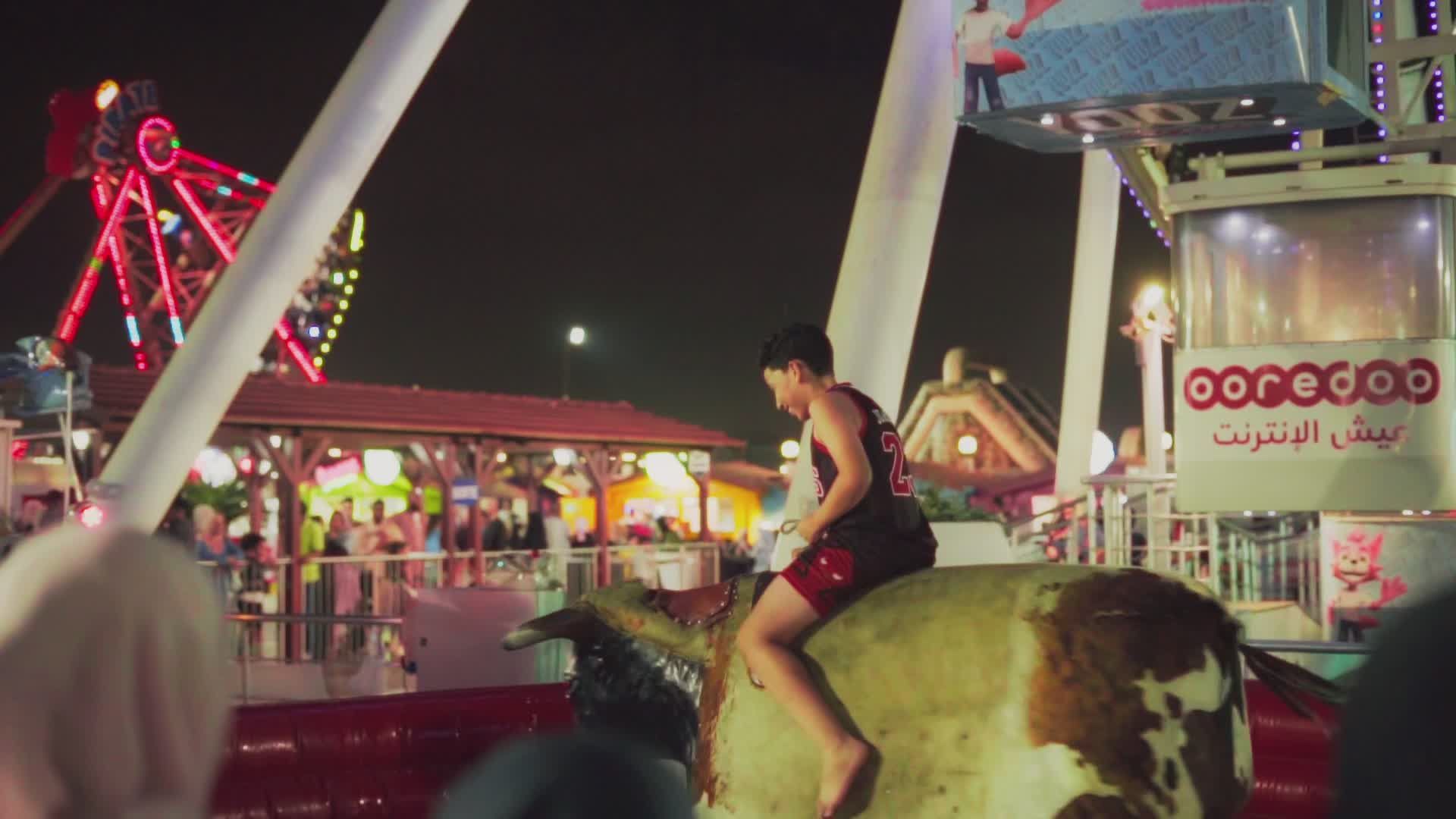 Child Riding Mechanical Bull in Vibrant Amusement Park Free Stock Video ...