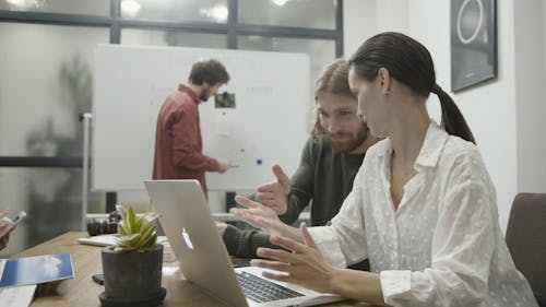 A Man Explaining To Woman Information On Topics Written On The White Board