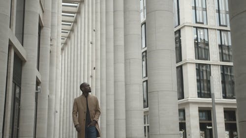 Man Looking Around While Walking Outside A Building