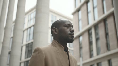 Man Looking Around While Waiting Outside The Building