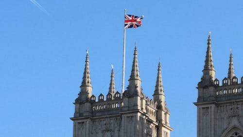一幢帶有羅馬建築設計與屋頂上的英國國旗的低角度鏡頭