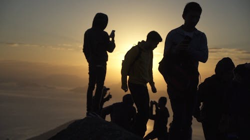 Grupa Mężczyzn Cieszących Się Widok Zachodu Słońca Ze Wzgórza