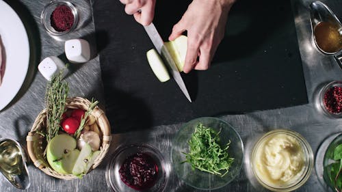 Cutting A Green Apple Into Pieces Using A Knife