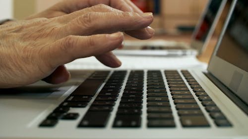 A Person Typing On A Laptop Keyboard