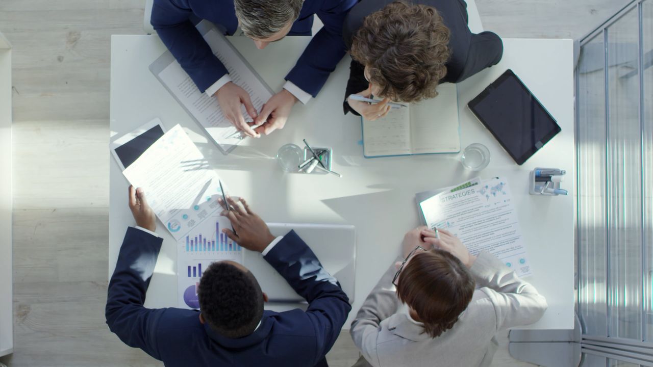 Professionals reviewing documents and data around a meeting table