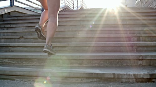 Backside Of A Woman Running Up An Outdoor Stairs