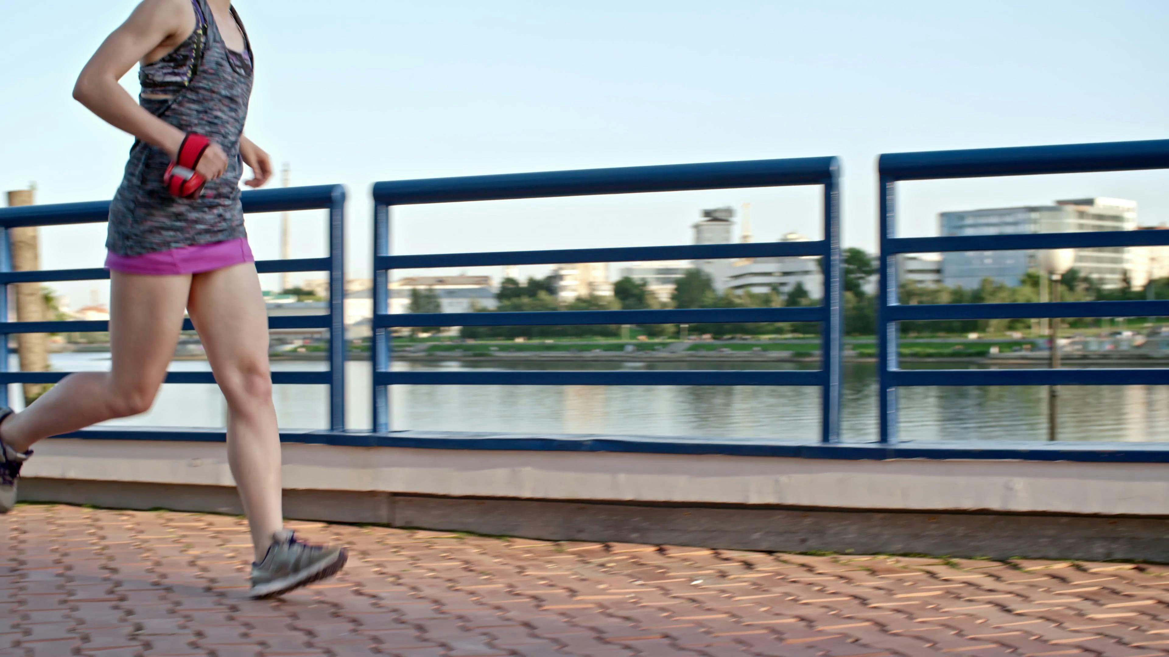 A Woman Running On A Concrete Pavement Built Above The Riverbank · Free