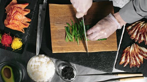 Couper Les Concombres En Longues Tranches Minces Comme Ingrédient Pour Le Petit Pain De Sushi