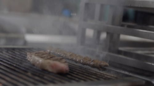 Cooking A Steak And Beef Kebab On A Charcoal Grill