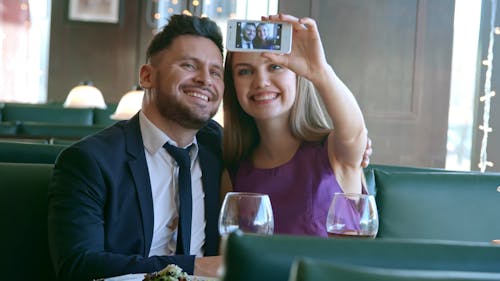 An Engaged Couple Taking A Video Of Themselves Using A Smartphone