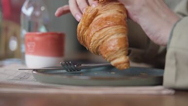 enjoying a fresh croissant breakfast indoors