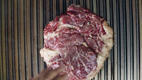 Flipping A Steak On A Pan Grill To Cook The Other Side