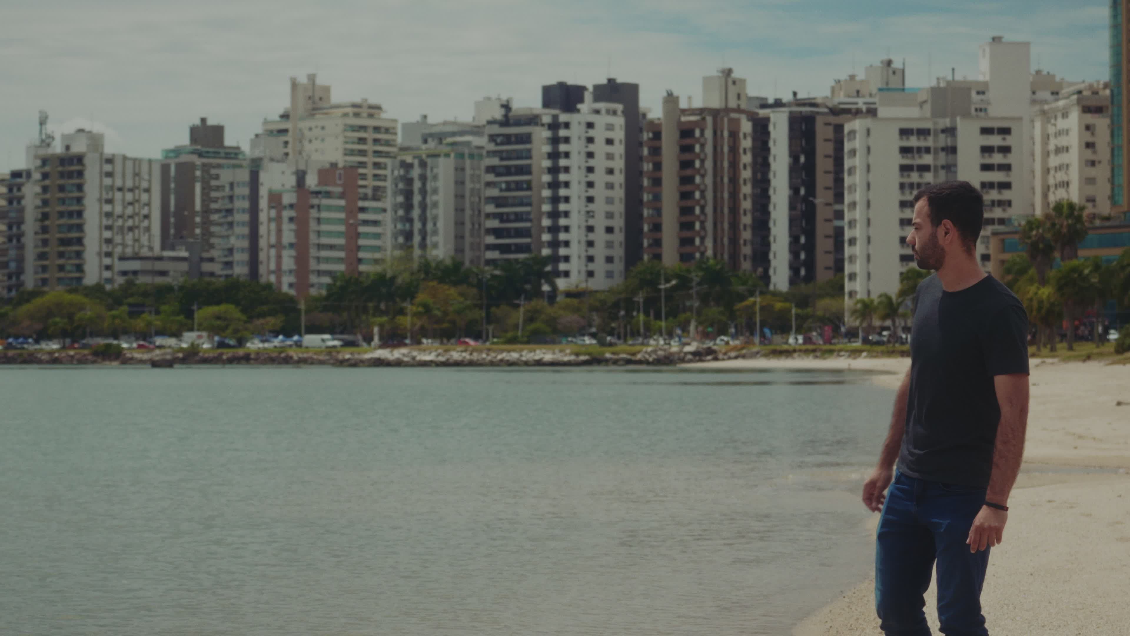 Man Strolling by the Beach with Cityscape View Free Stock Video Footage ...