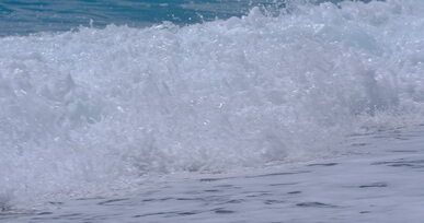 tropical ocean waves crashing on sandy beach