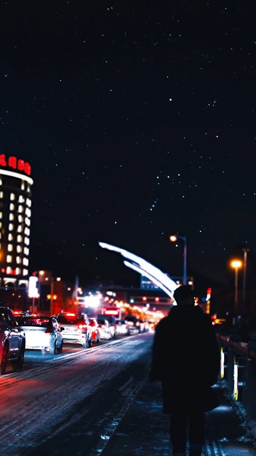 Een Man Lopen Langs De Weg In De Stad 'S Nachts