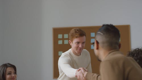 A Man Introducing Himself To A In A Business Meeting By Shaking Their Hands