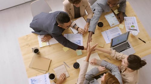 A Group Of People Shaking Each Others Hand In A Business Meeting