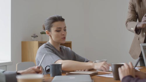 A Woman Asking About A Point On The Document Presented On The Table