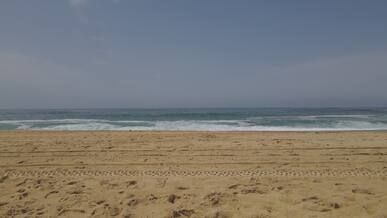 aerial view of ocean waves on sandy beach