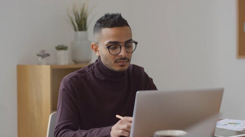 Man Wearing Eyeglasses in Front of His Computer Typing 