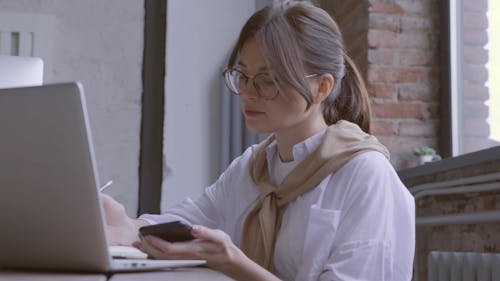 Femme Occupée Travaillant Avec Son Ordinateur Portable Et Son Smartphone