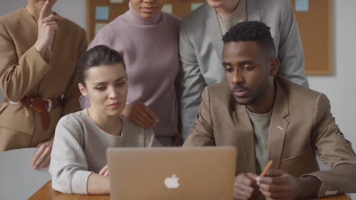 Group Of People Discussing About The Information They Have On The Laptop