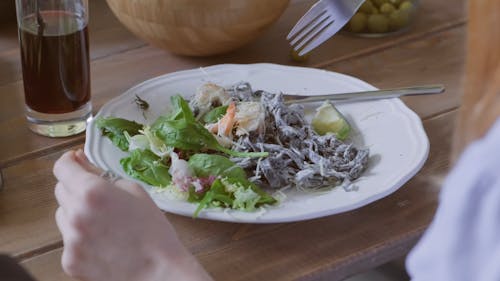 Een Persoon Die Een Pastagerecht Met Salade Eet