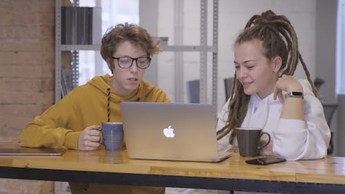 Two Women In Discussion Using A Laptop