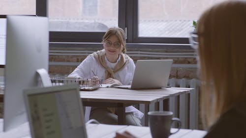 妇女在笔记本电脑上工作时的谈话