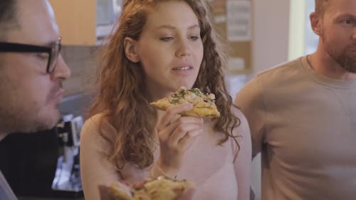 A Group Of People Eating Pizza While On Break At The Workplace