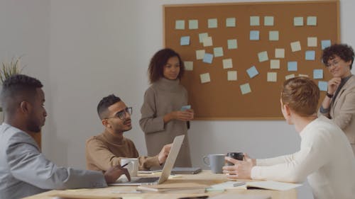 A Group Of People Brainstorming In A Meeting Room And Happily Agreeing With A Handshake On A Plan