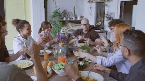 A Group Of People Having A Working Lunch Over A Wooden Table