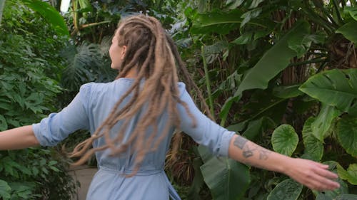 A Woman Turning Around Repeatedly Inside A Greenhouse