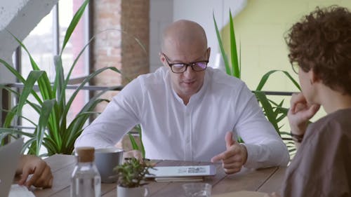 A Man And A Woman Having A Discussion About A Data Stored On A Smart Pad