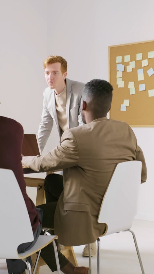 Un Hombre De Pie Tomando La Iniciativa Mientras Habla En Una Reunión De Negocios