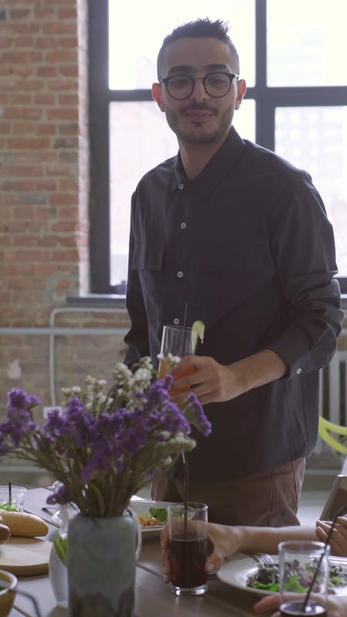 A Man Talking While Standing Beside The Dining Table