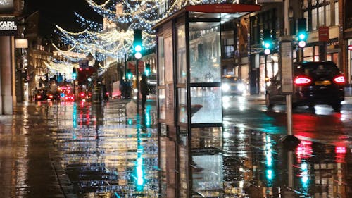 聖誕燈裝飾在倫敦一條街的濕路面上的思考