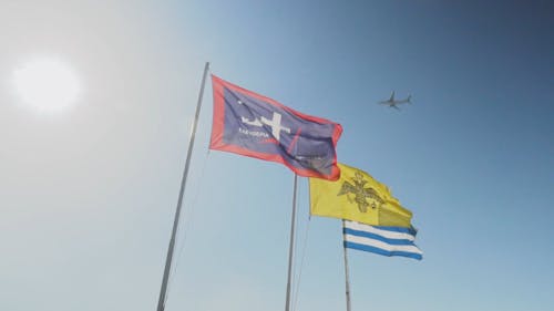 Three Flags Swaying By The Wind On Its Flagpoles