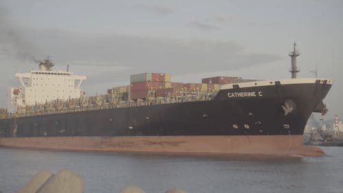 A Cargo Ships With Containers Entering The Harbor