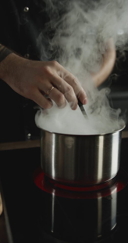 A Chef Preparing Then Tasting The Hot Broth For A Dish