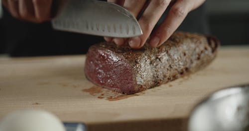 Person Cutting Beef Into Slices