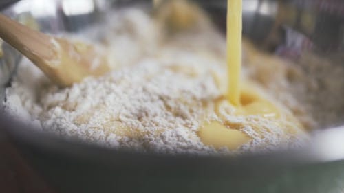 Stirring Flour And Condensed Milk In A Mixing Bowl