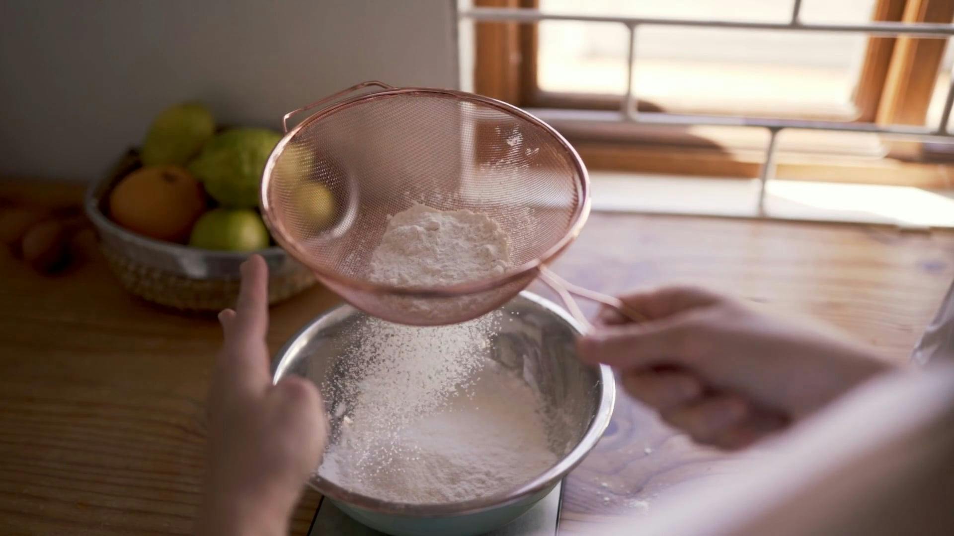 A Person Straining The Flour To Be Used In Baking · Free