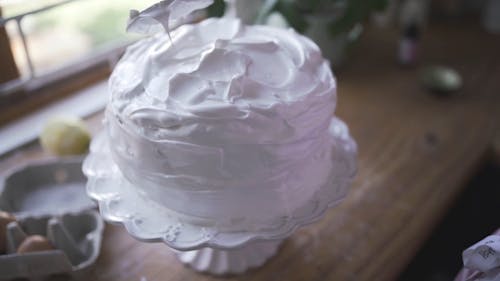 A Baker Applying Icing On A Cake