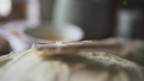 Topping A Baked Cake With icing Using A Wooden Spatula
