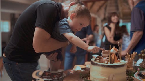 彼のケーキの動物のイメージの装飾に触れる誕生日の男の子