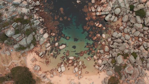 A Water Lagoon Surrounded By Boulders Of Rock