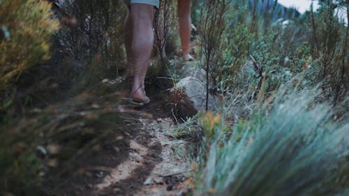 A Couple Wearing Slippers Walking On A Hiking Trail