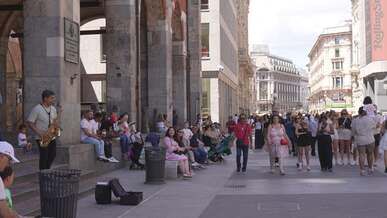 bustling street in central milan with musician