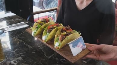 delicious beef tacos on rustic board at restaurant